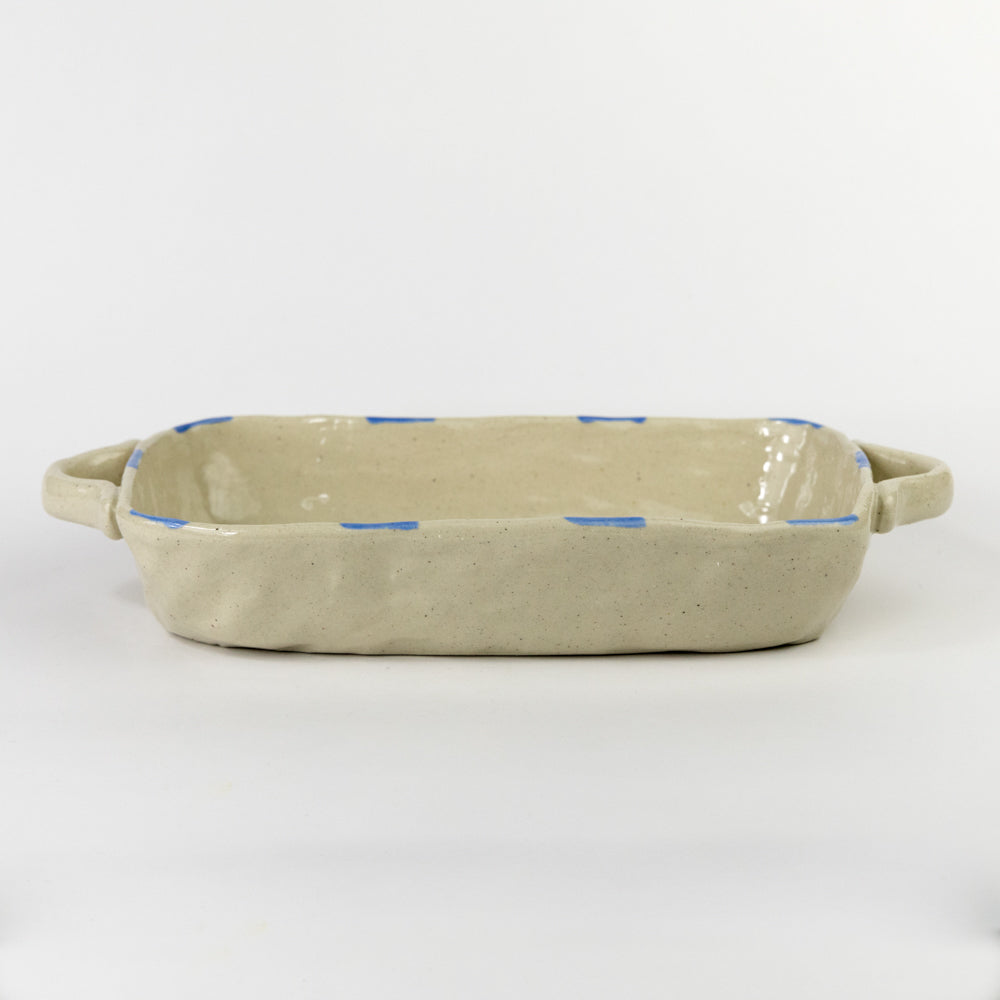 Beige ceramic dish with blue accents on a white background