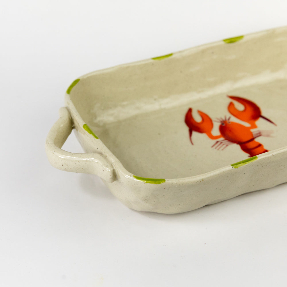 Rectangular ceramic dish with a red lobster design on a beige background