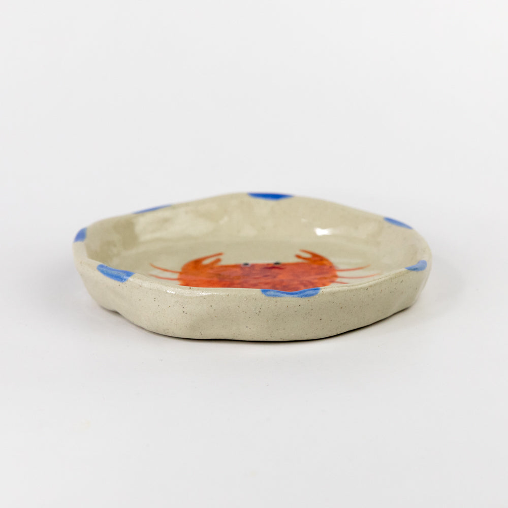 Ceramic dish with a red crab design on a white background