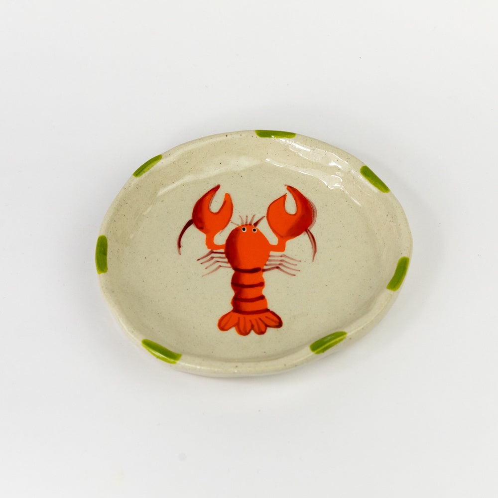 Small ceramic plate with a red lobster design on a white background