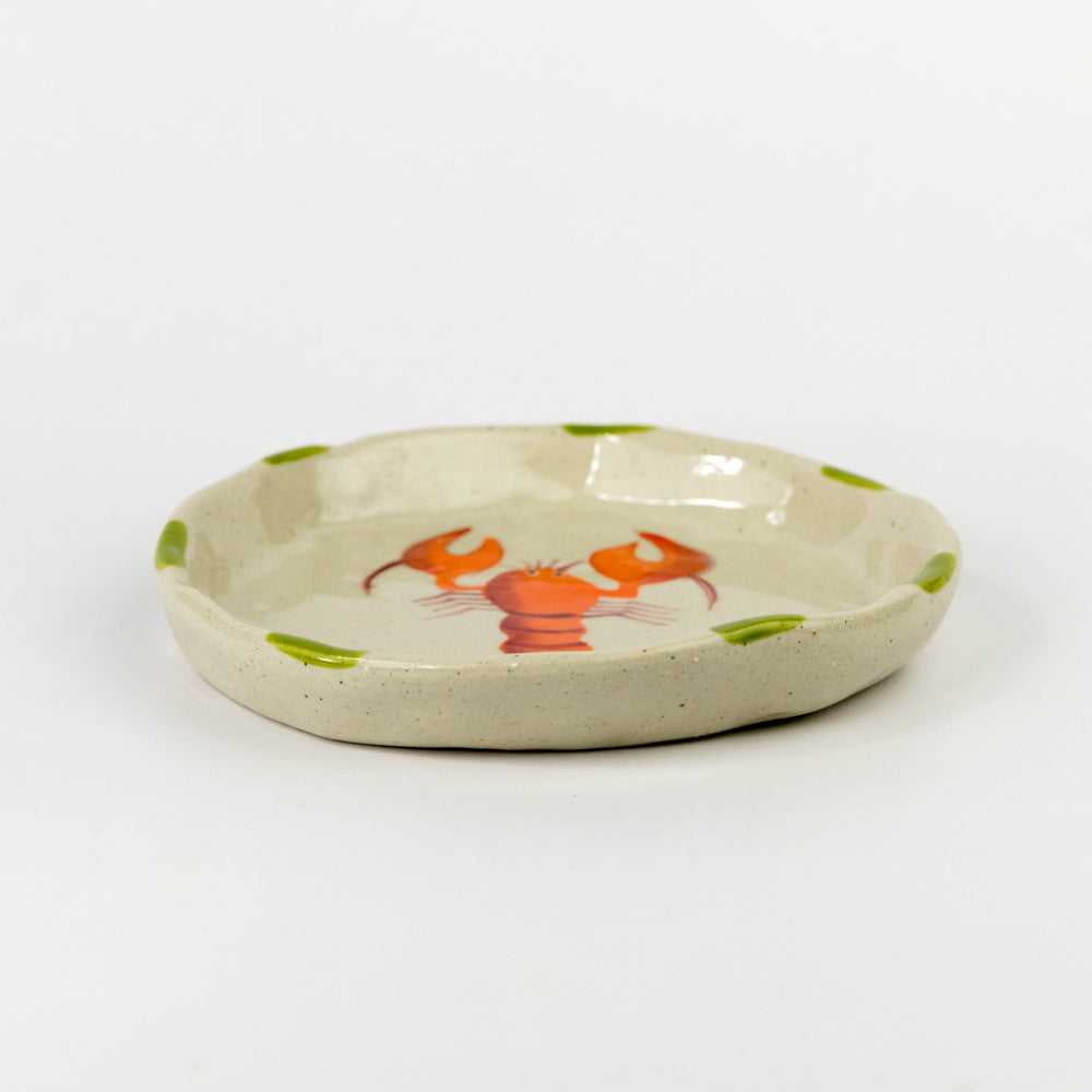 Small ceramic plate with a red lobster design on a white background