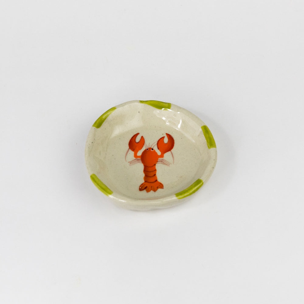 Small ceramic dish with a red lobster design on a white background