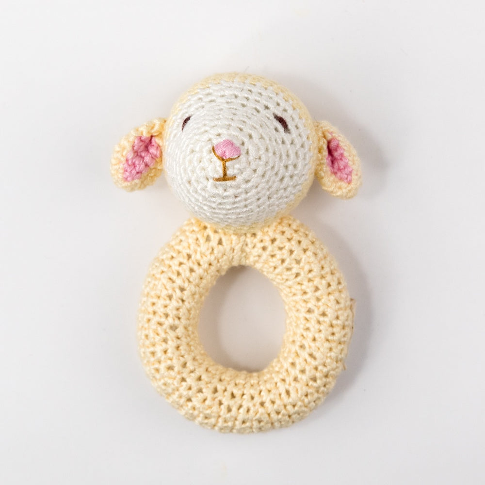 Crocheted sheep rattle toy on a white background
