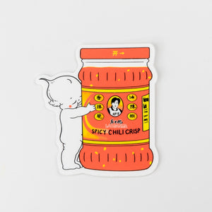 Sticker of a kewpie baby hugging a container of 'Spicy Chilli Crisp' on a white background