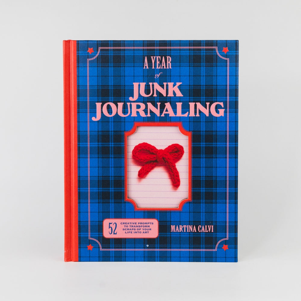 Book titled 'A Year of Junk Journaling' with blue plaid design and red accents on a white background