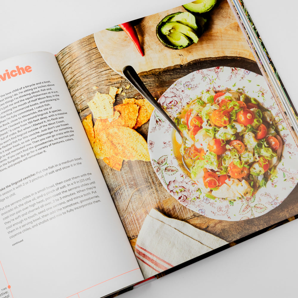 Open cookbook showing a page with a recipe and a plate of food on a wooden board.