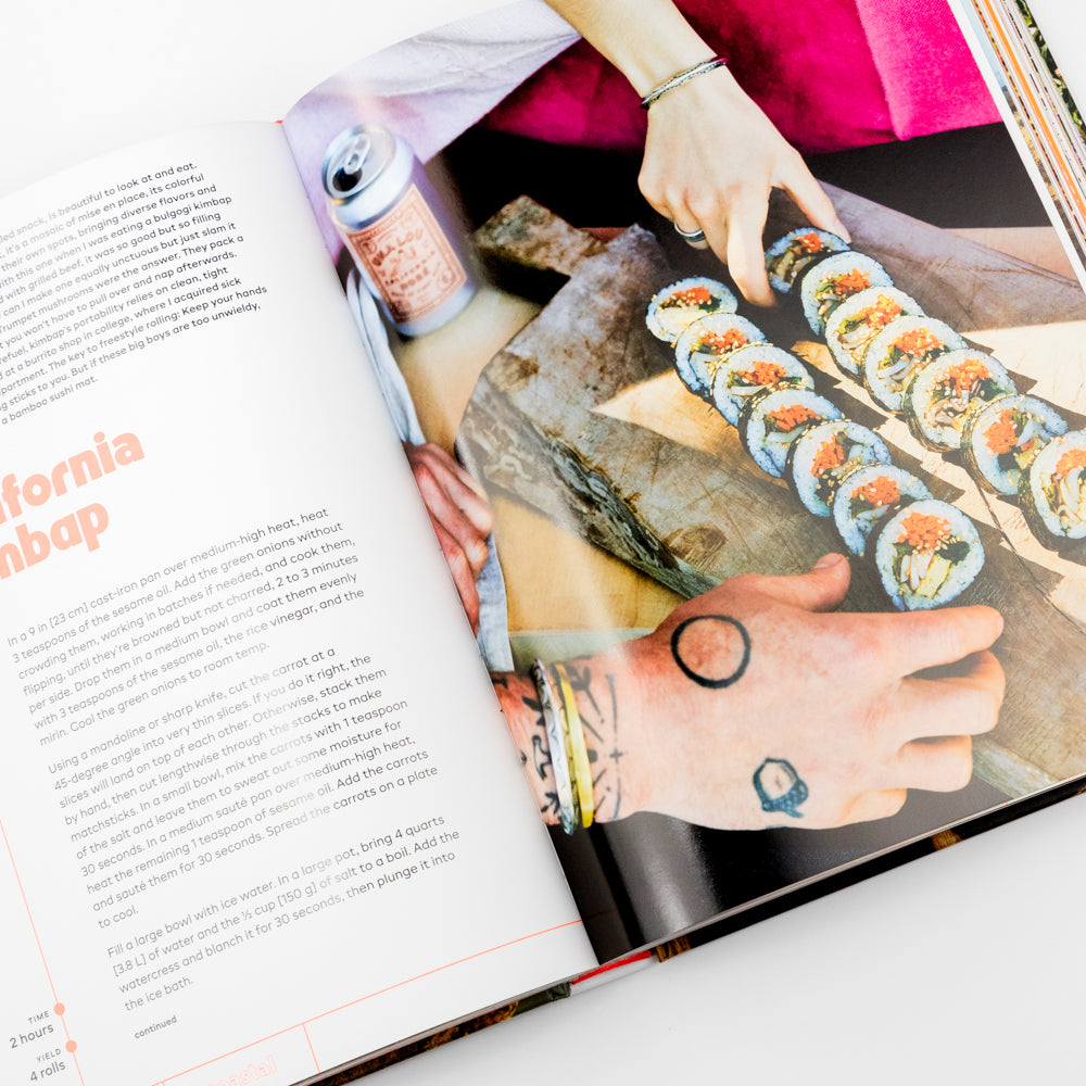 Open book showing a page with sushi and a person's hands