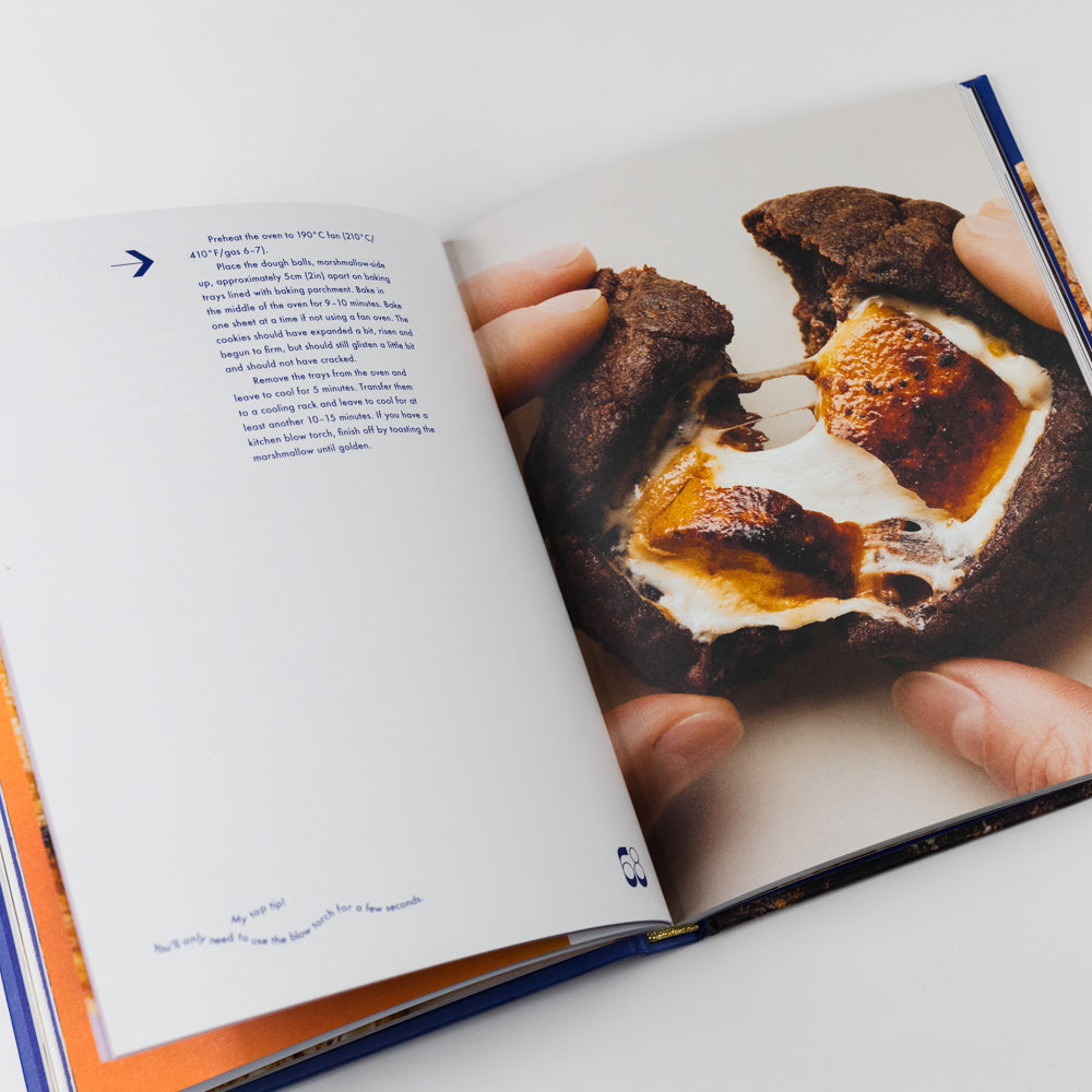 Open book showing a page with a photo of a hand holding a piece of bread with a gooey filling.