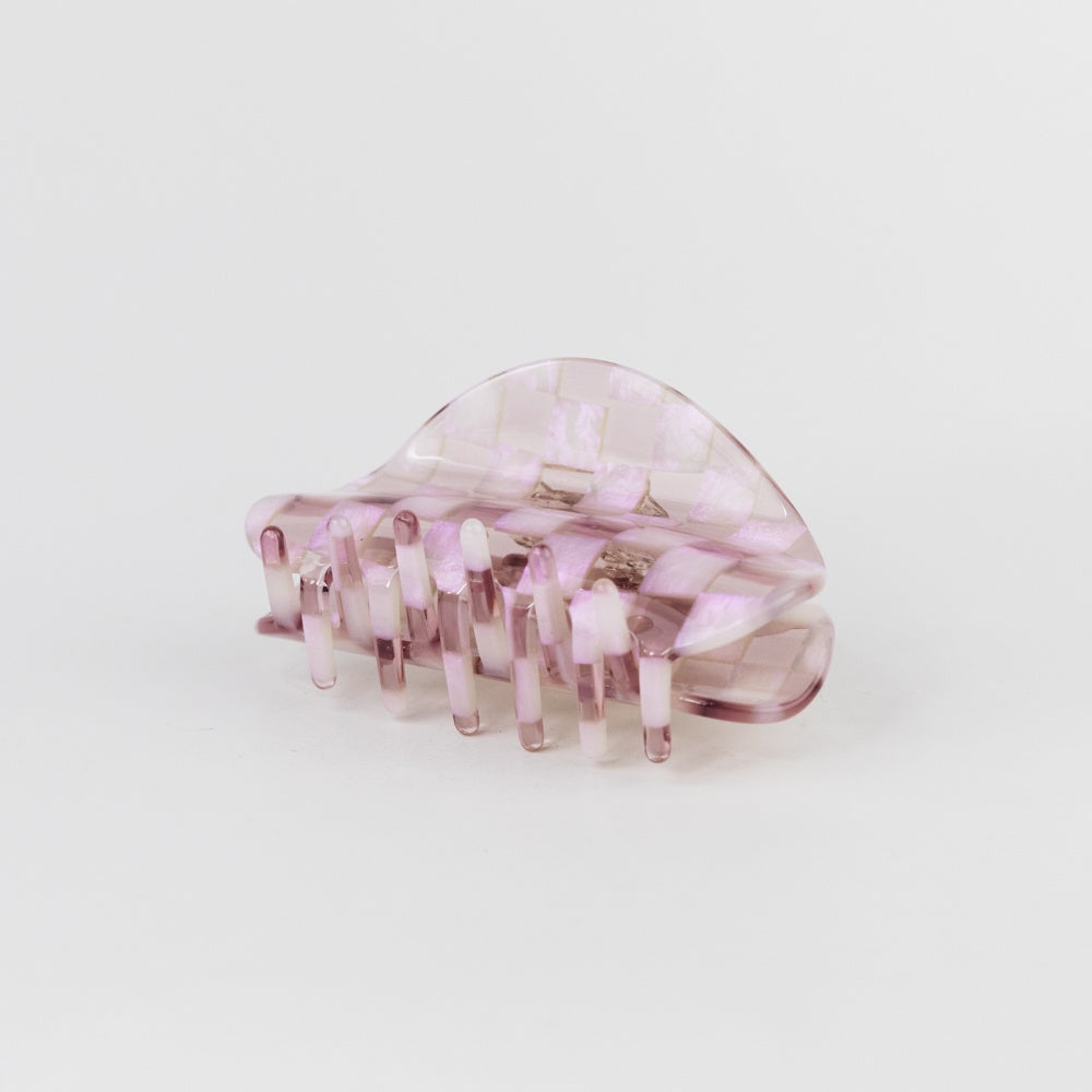 Pink hair clip on a light gray background