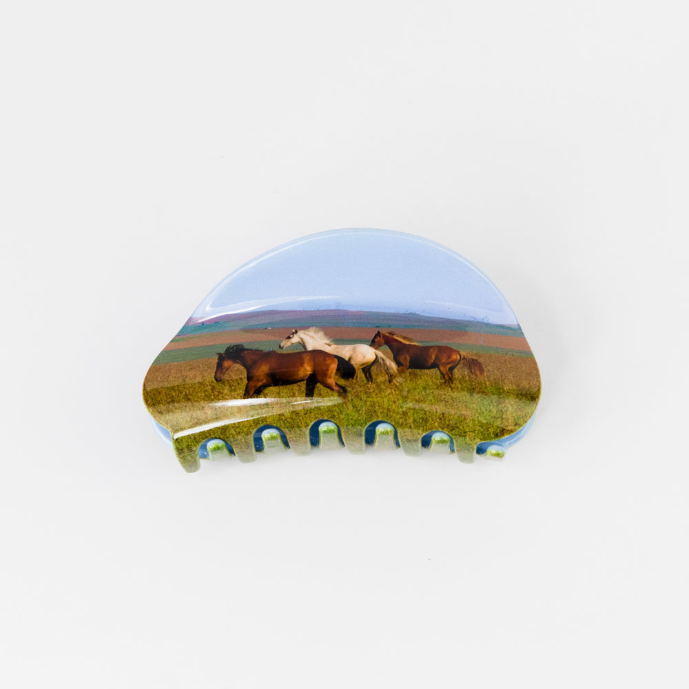 Hair claw with horses in a field design on a white background