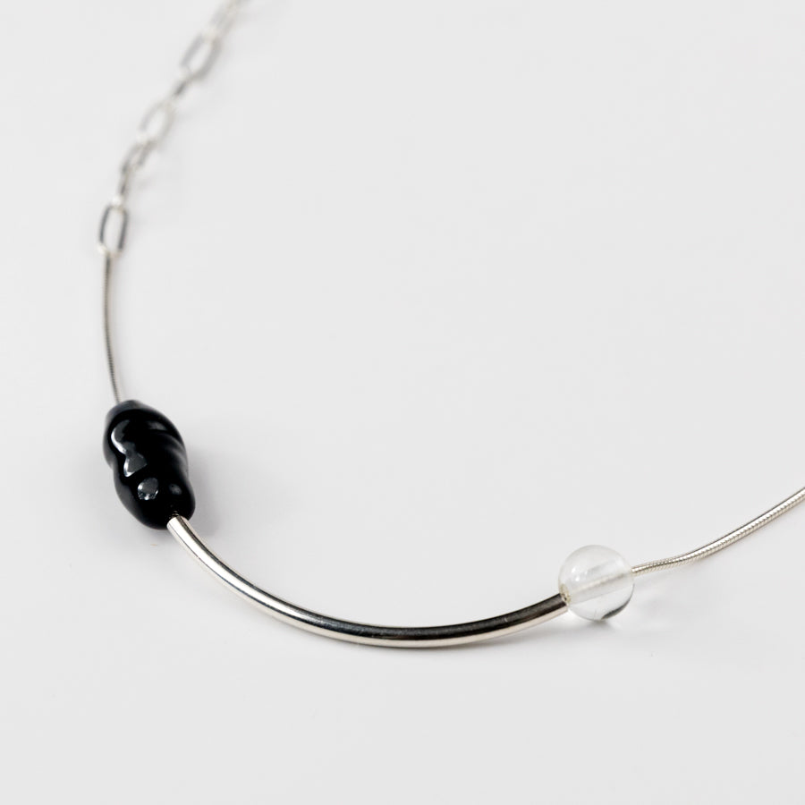Necklace with black and clear beads on a white background