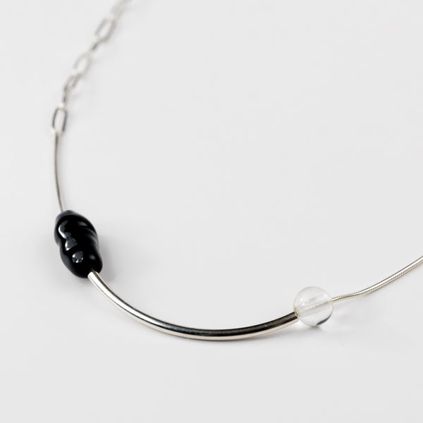 Necklace with black and clear beads on a white background