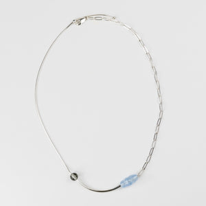 Silver necklace with a blue pendant on a light gray background
