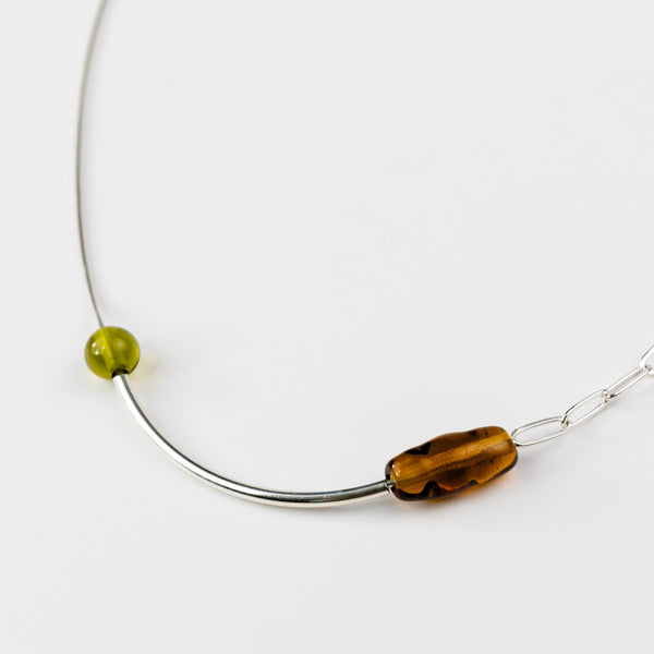 Necklace with two beads, one green and one brown, on a white background