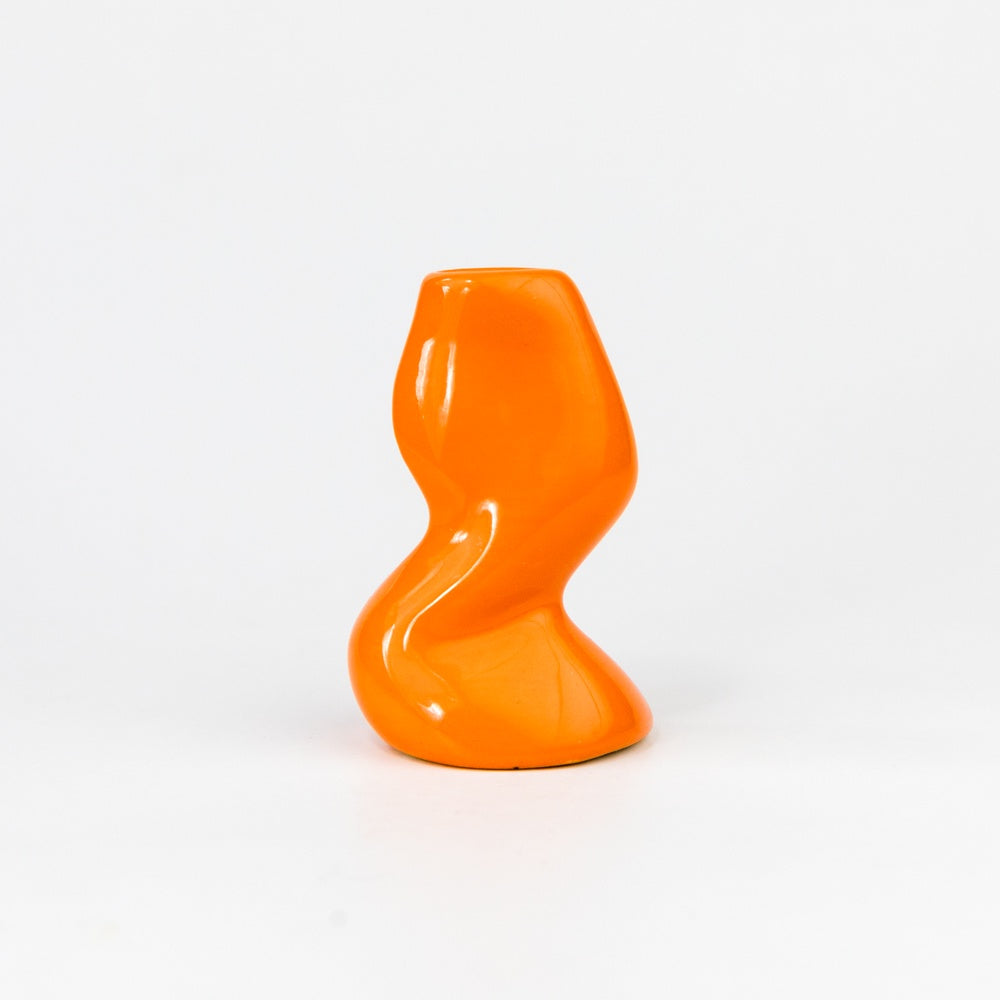 Orange ceramic vase with a unique spiral design on a white background