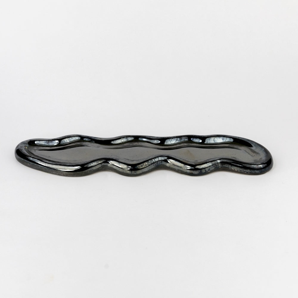 Black wavy ceramic dish on a white background