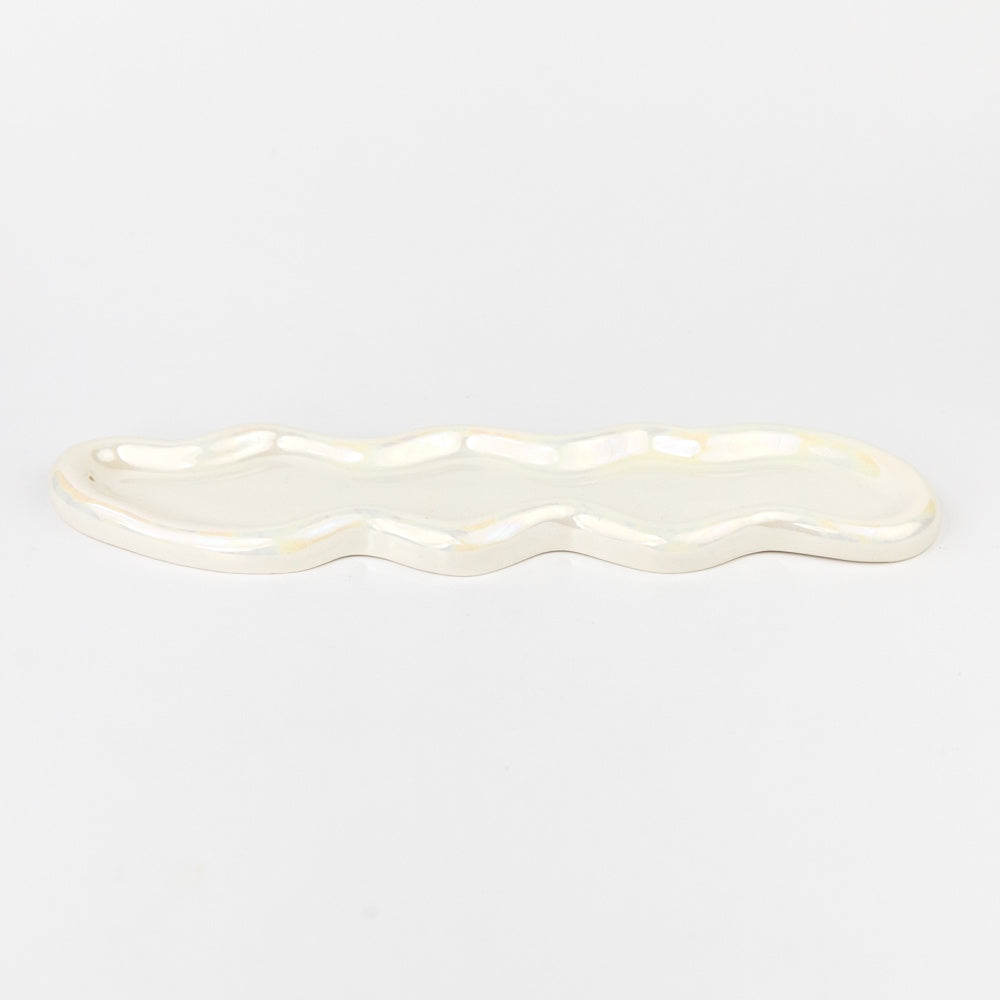 White ceramic dish with wavy edge on a light gray background