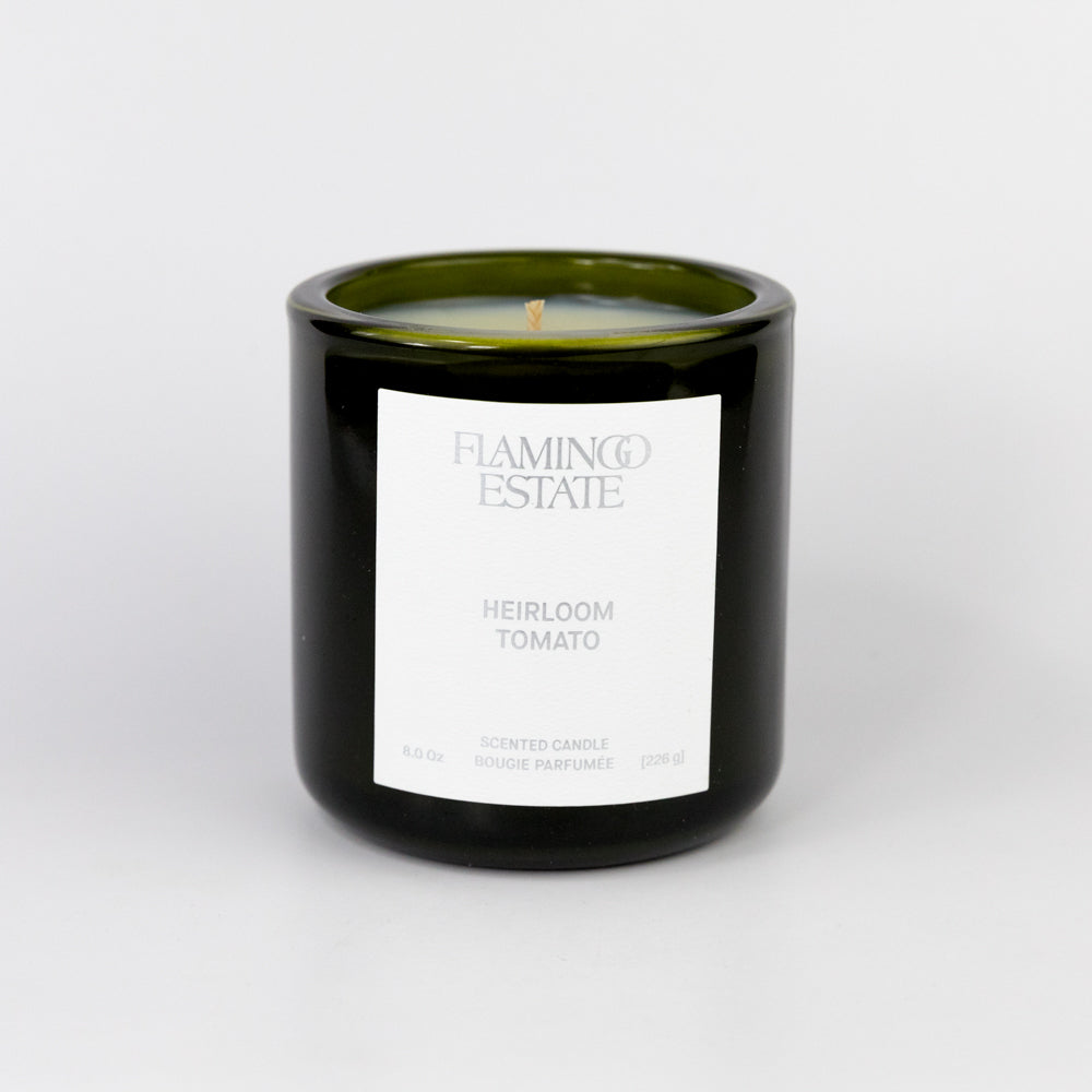 Candle in a black container with a white label on a light gray background