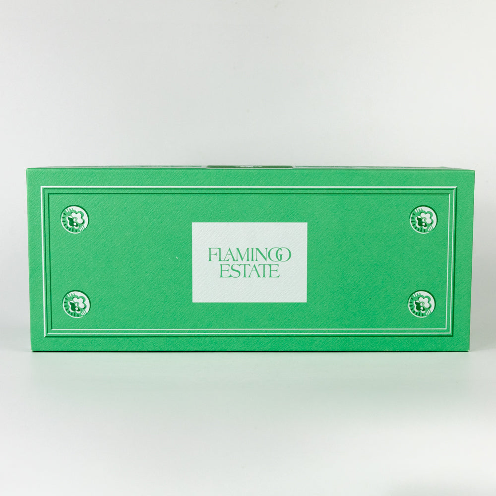 Three green candles on a matching green holder against a white background