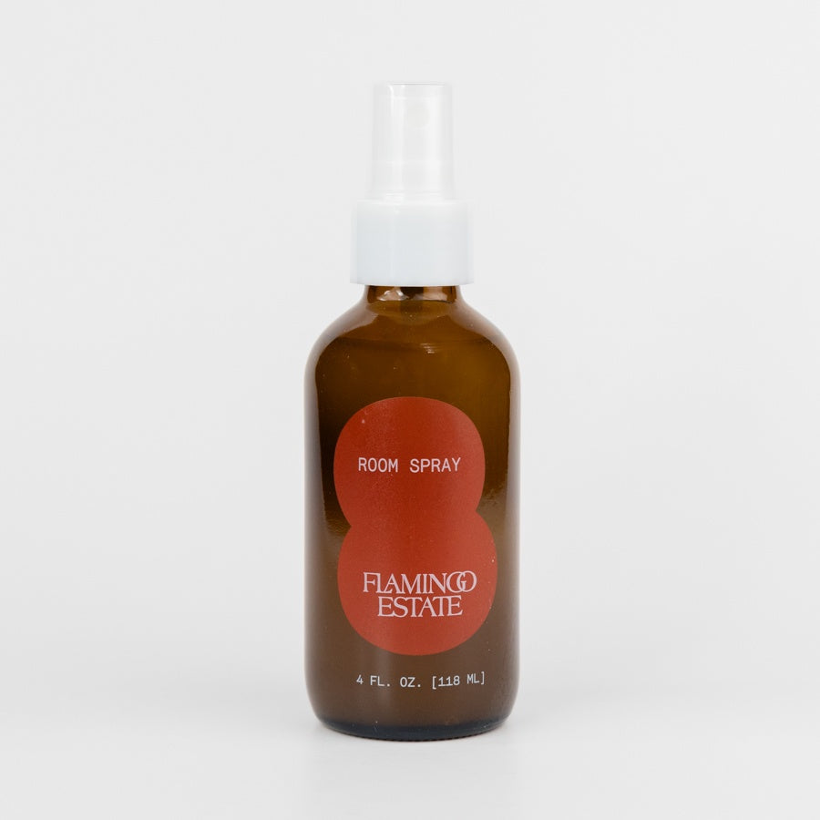 Brown room spray bottle with red label on a white background