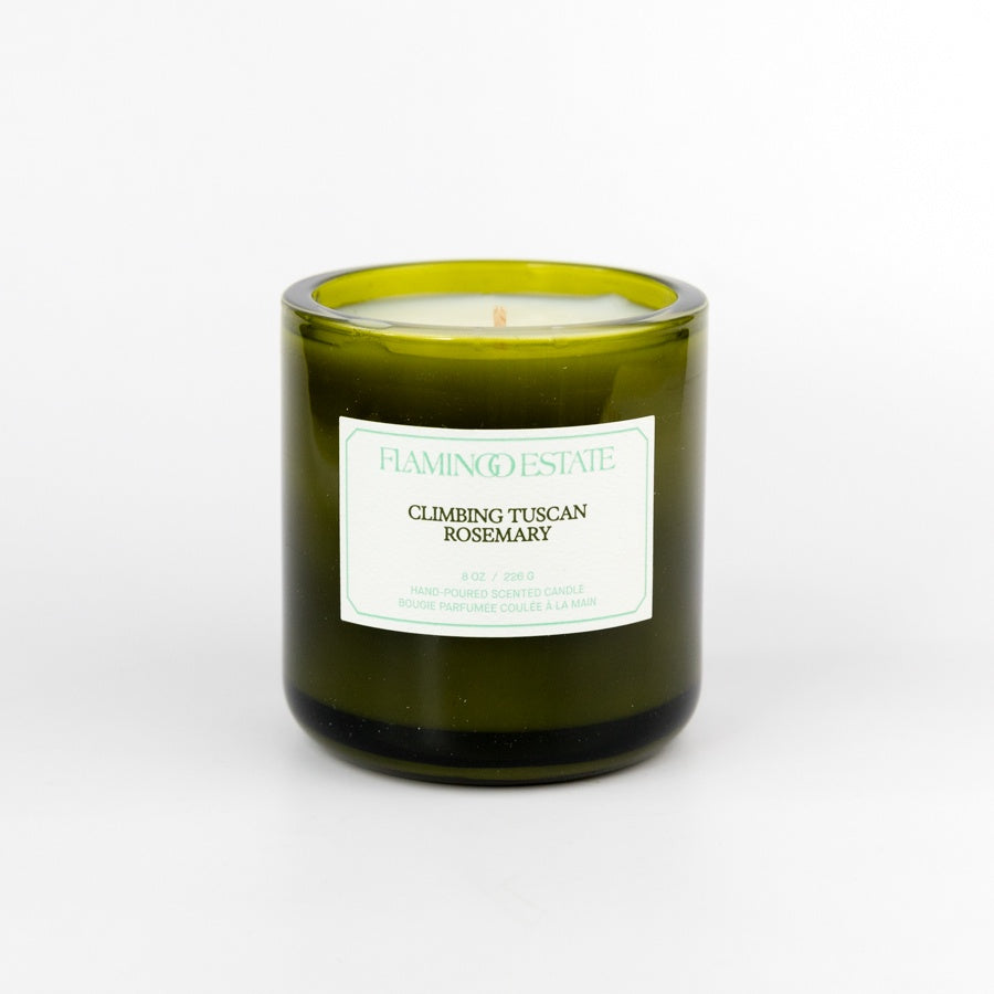 Green candle in a glass jar with a label on a white background