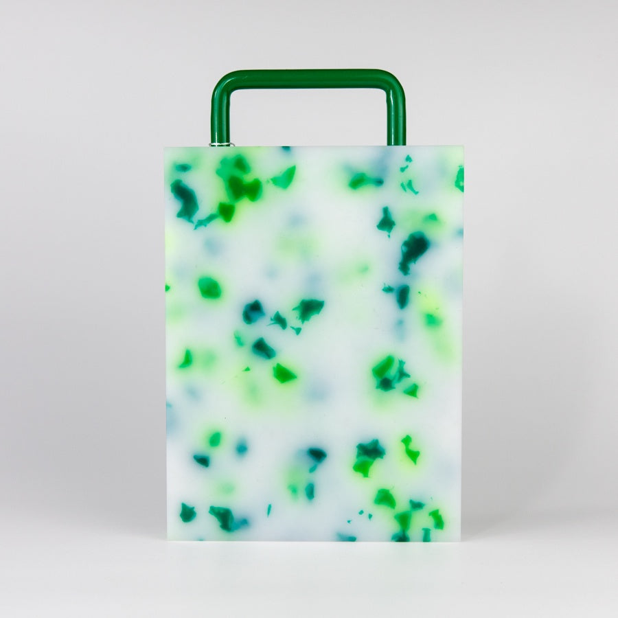 A small rectangular cutting board with a green and white marbled pattern, featuring a green handle on top for easy carrying.