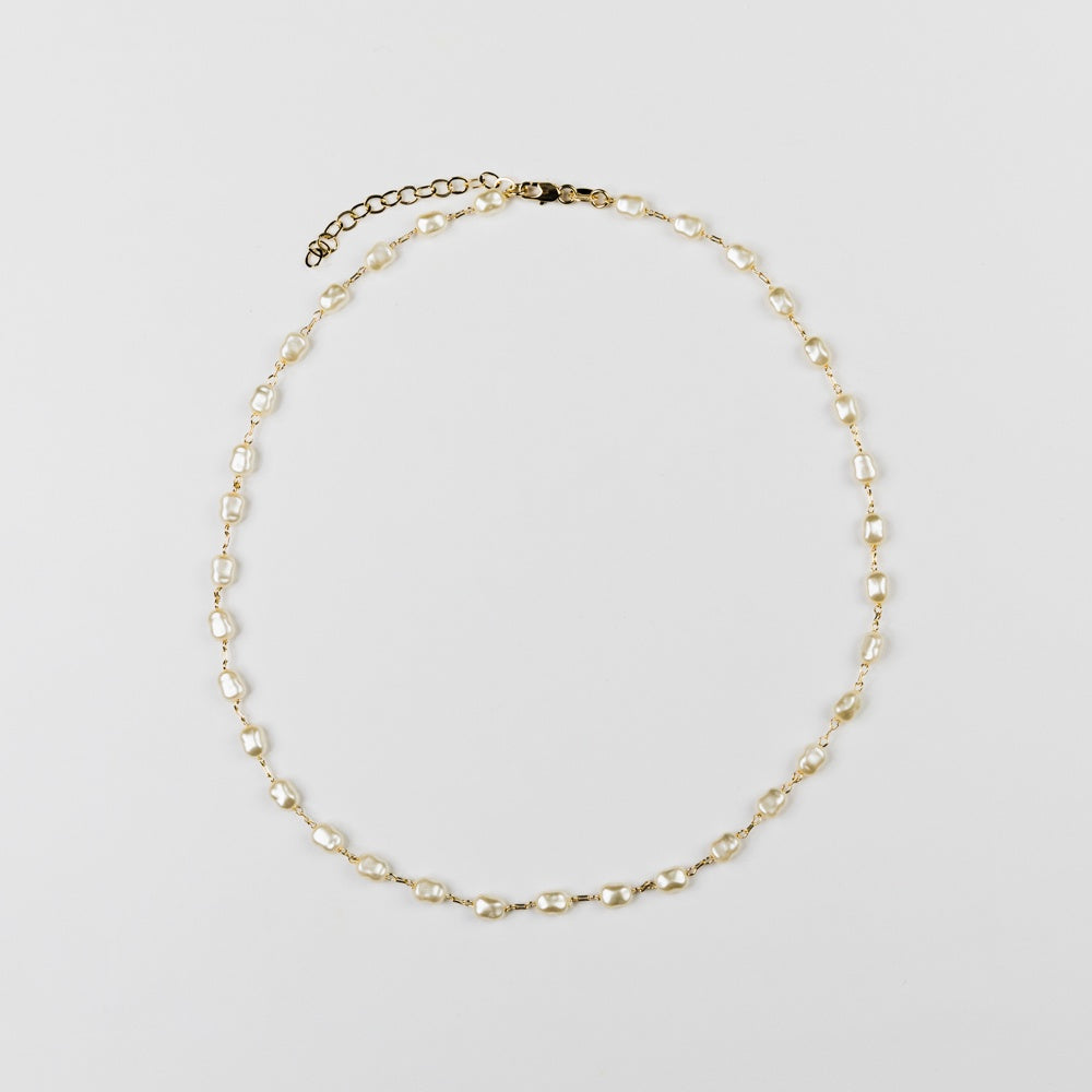 Pearl necklace on a light gray background