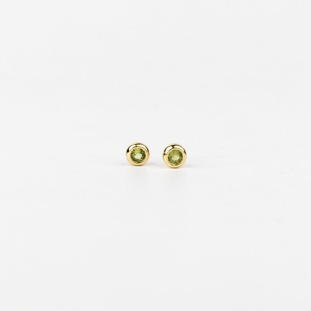 Pair of gold stud earrings with green gemstones on a white background