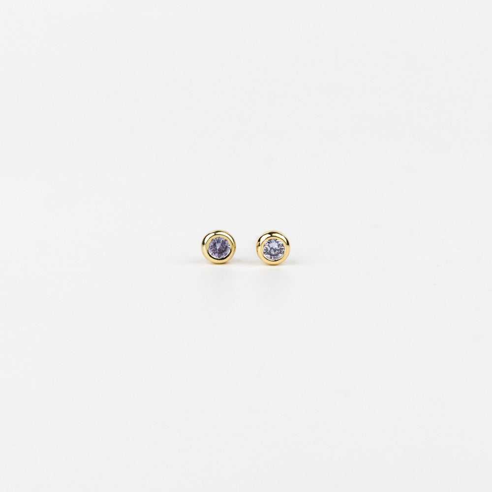 Pair of gold earrings with purple gemstones on a white background