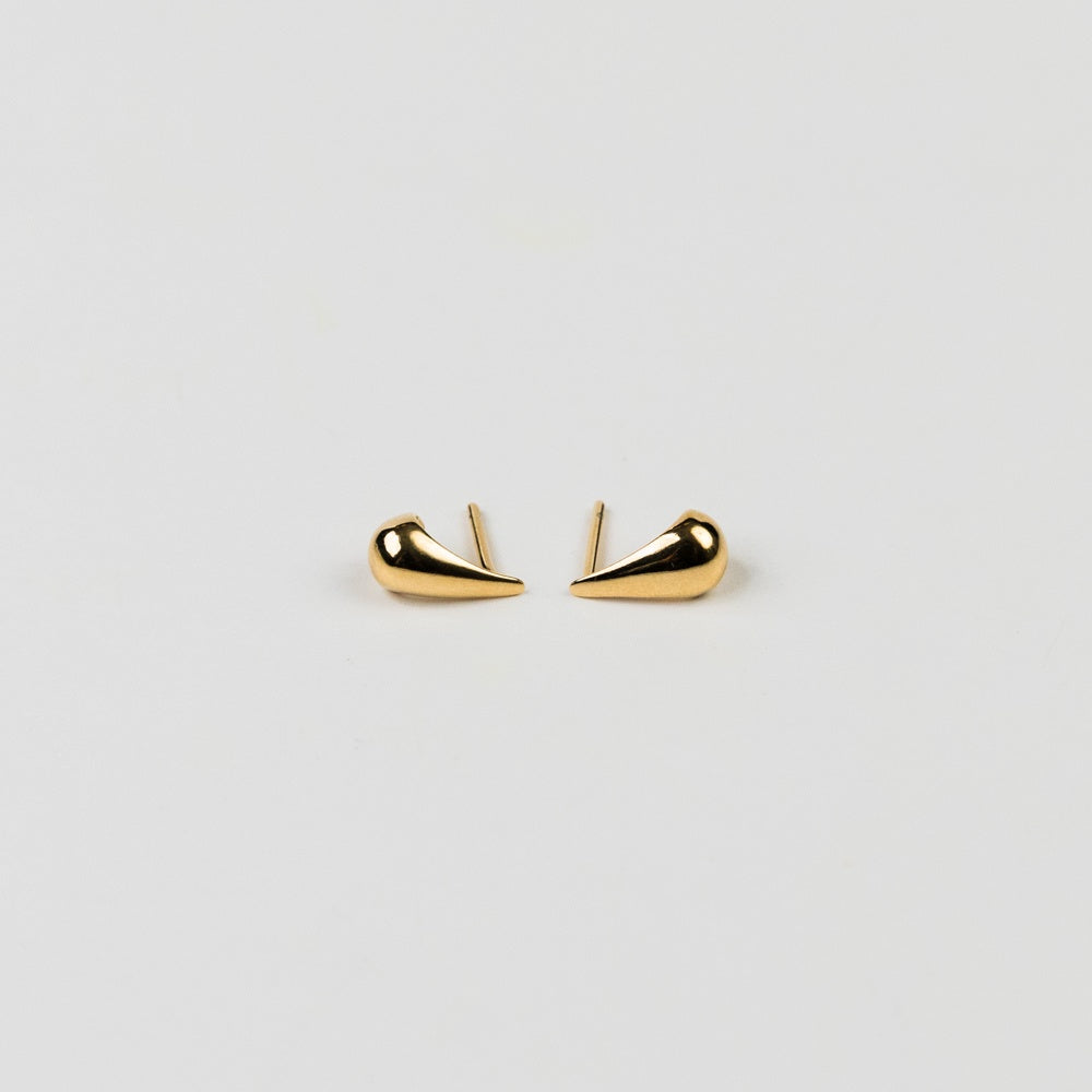 Gold earrings on a light gray background