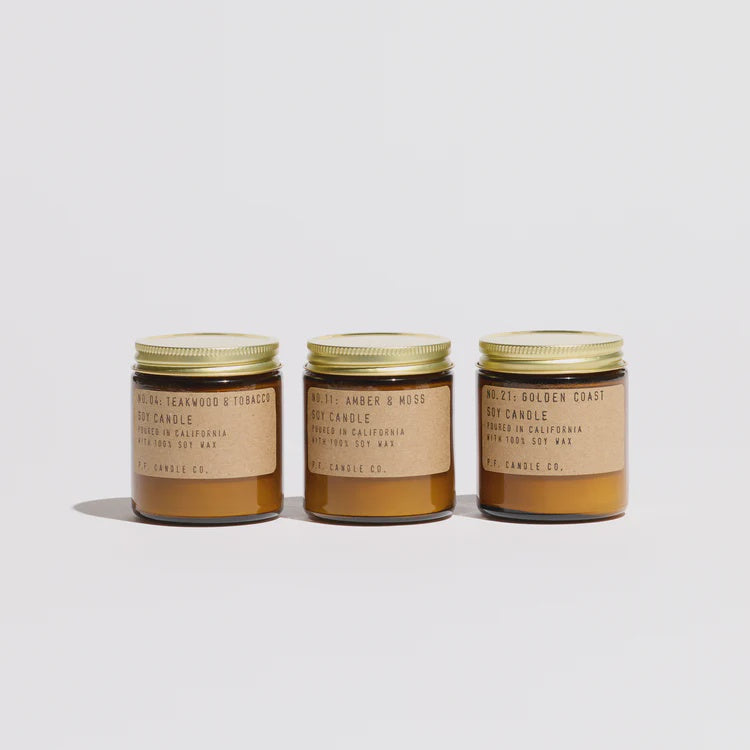 Three candles and a cylindrical packaging tube on a white background