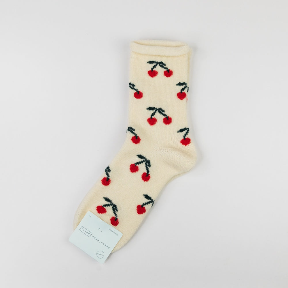 Beige sock with cherry pattern on a light gray background