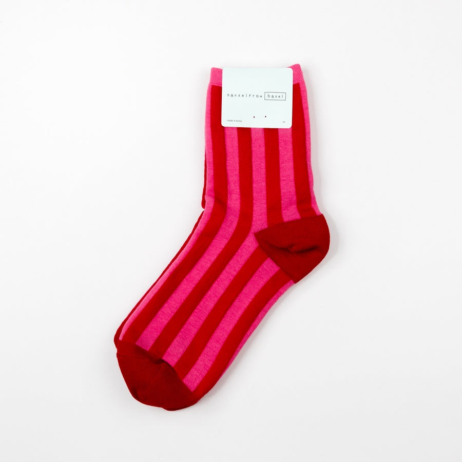 Red and pink striped sock with a brand label on a white background
