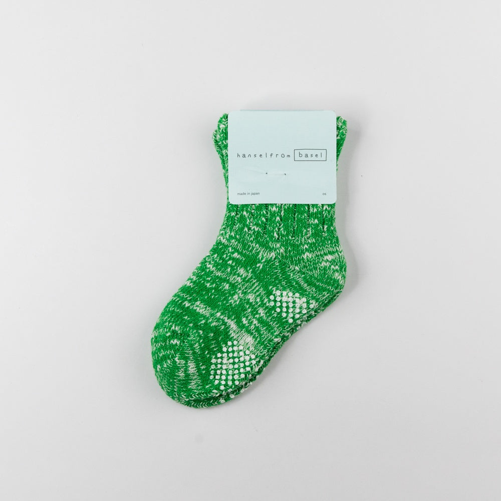 Green sock with a white pattern on a light gray background