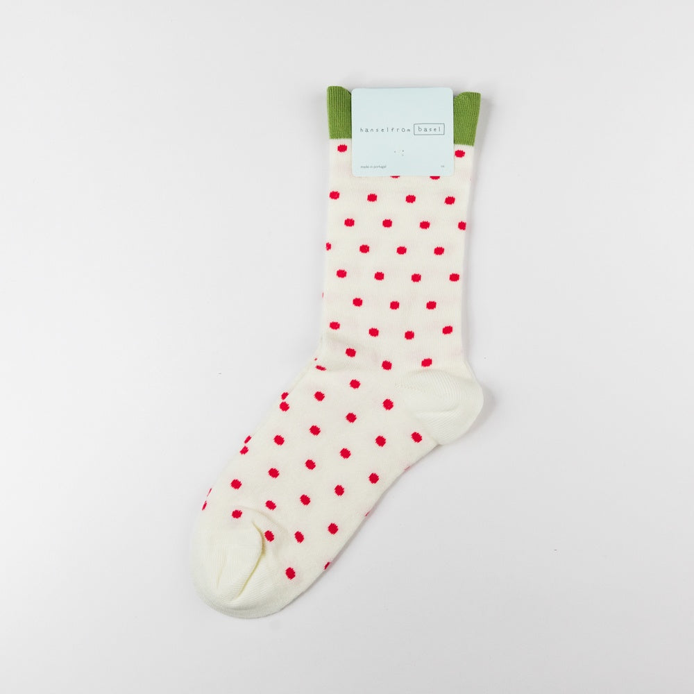 White sock with red polka dots on a light gray background
