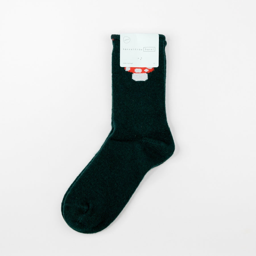 Dark green sock with a red cap mushroom design on a light gray background