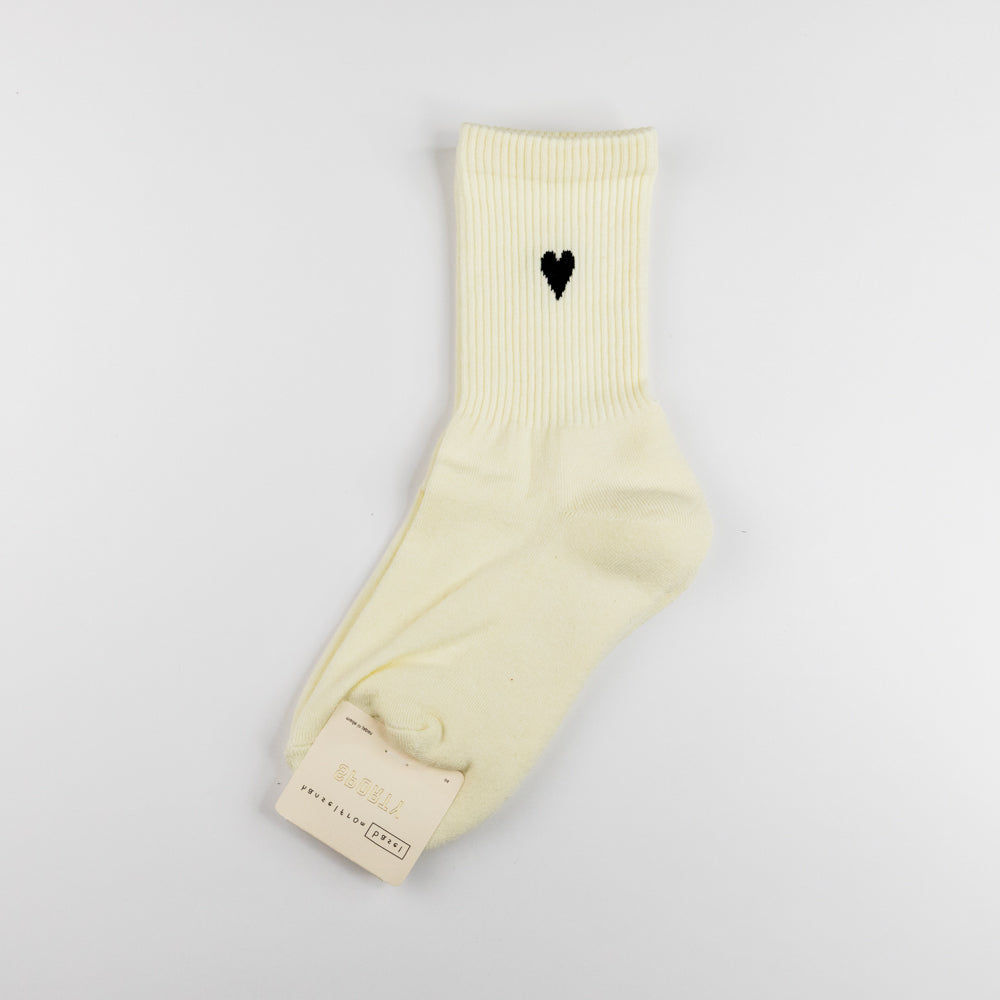 Beige sock with a black heart design on a light gray background