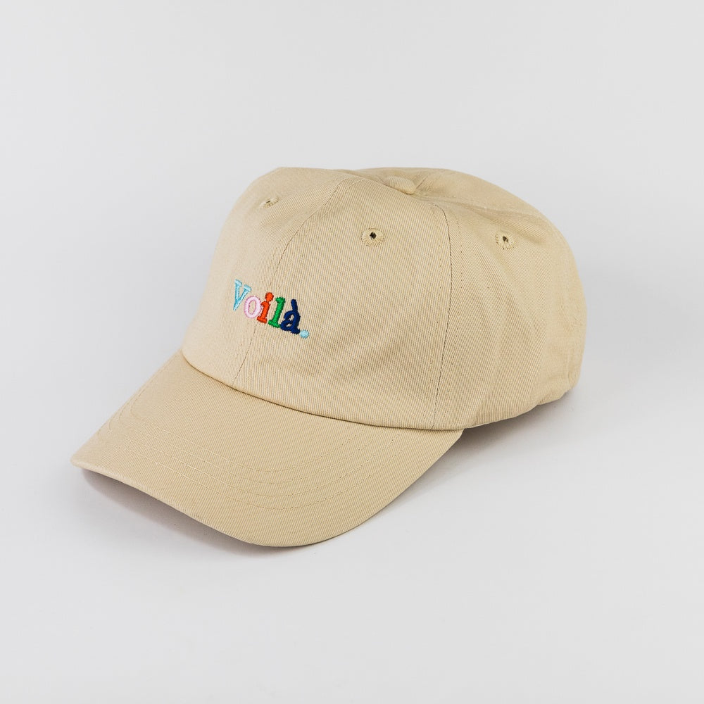Beige cap with colorful text on a light gray background