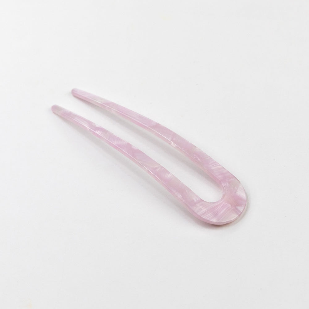 Pink hair clip on a light gray background