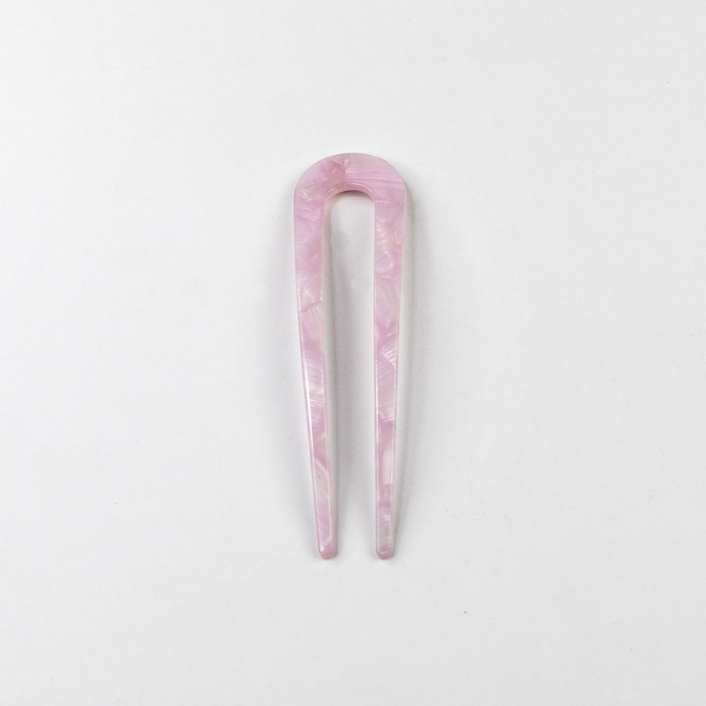 Pink marbled hair clip on a light gray background
