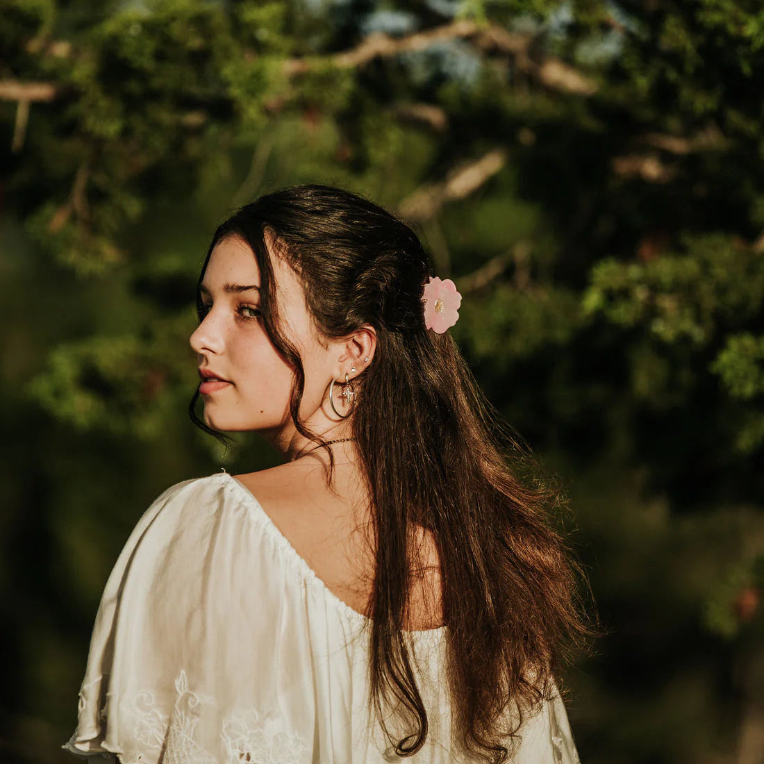 Pink hair clip with a gold center on a white background