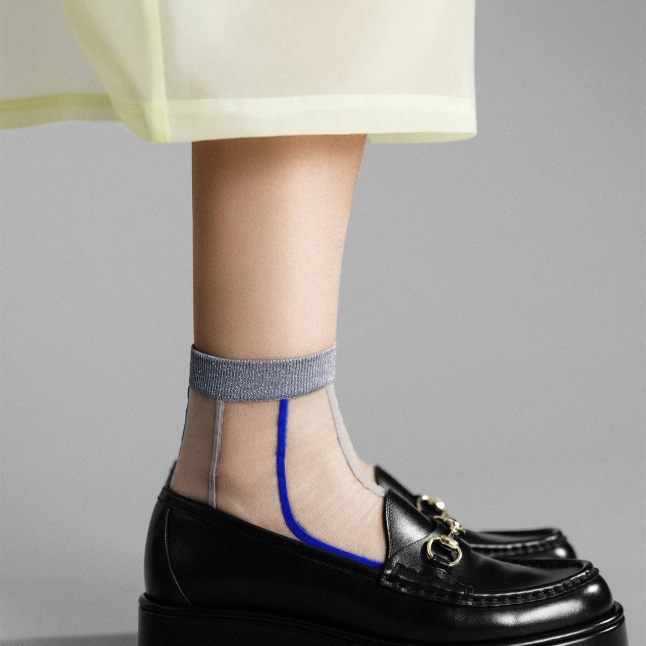 Pair of gray ankle socks with blue accents on a white background