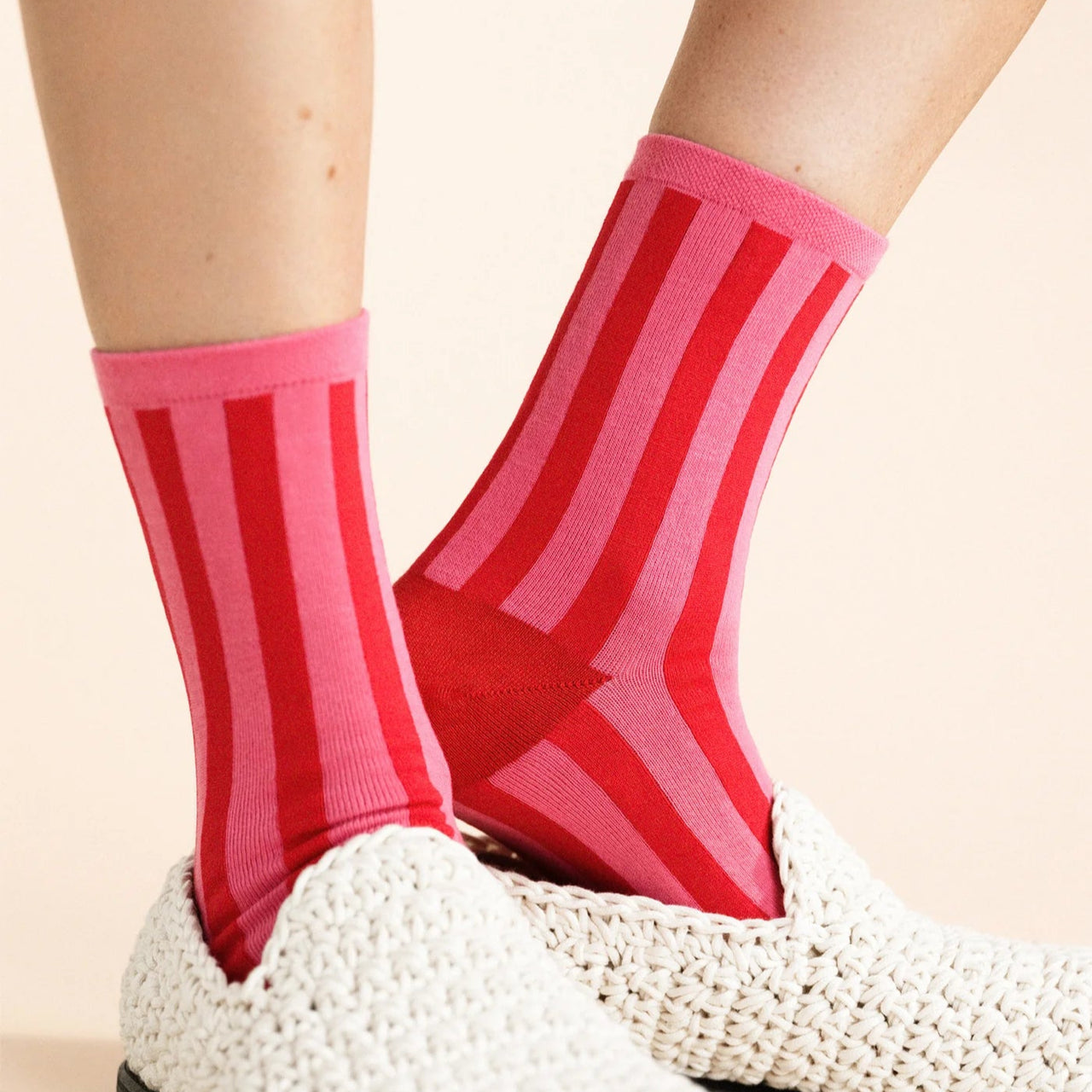 Red and pink striped sock with a brand label on a white background