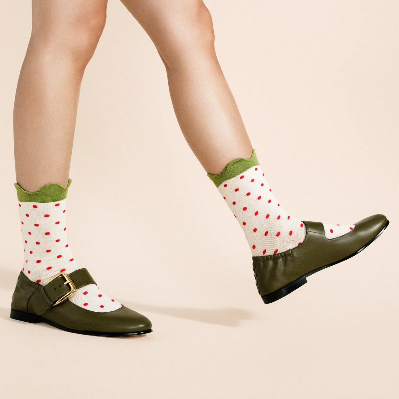 White sock with red polka dots on a light gray background