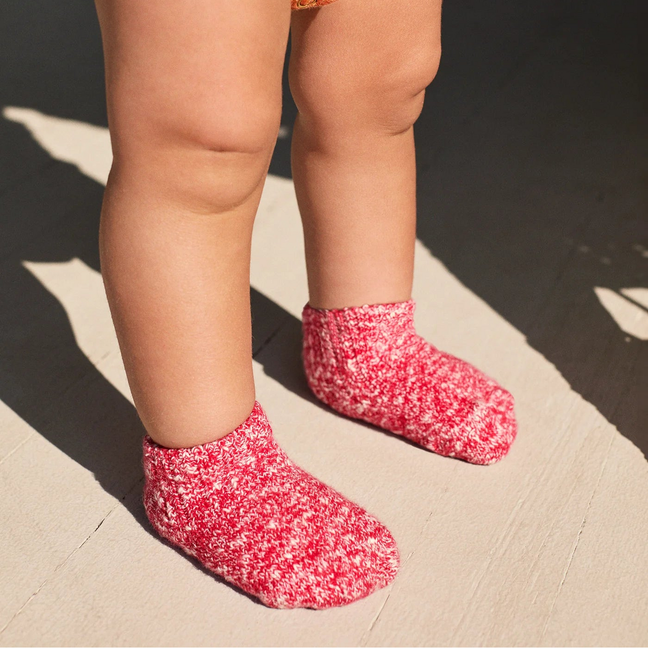 Green sock with a white pattern on a light gray background