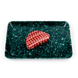 Rectangular green speckled tray with a red checkered object on a white background