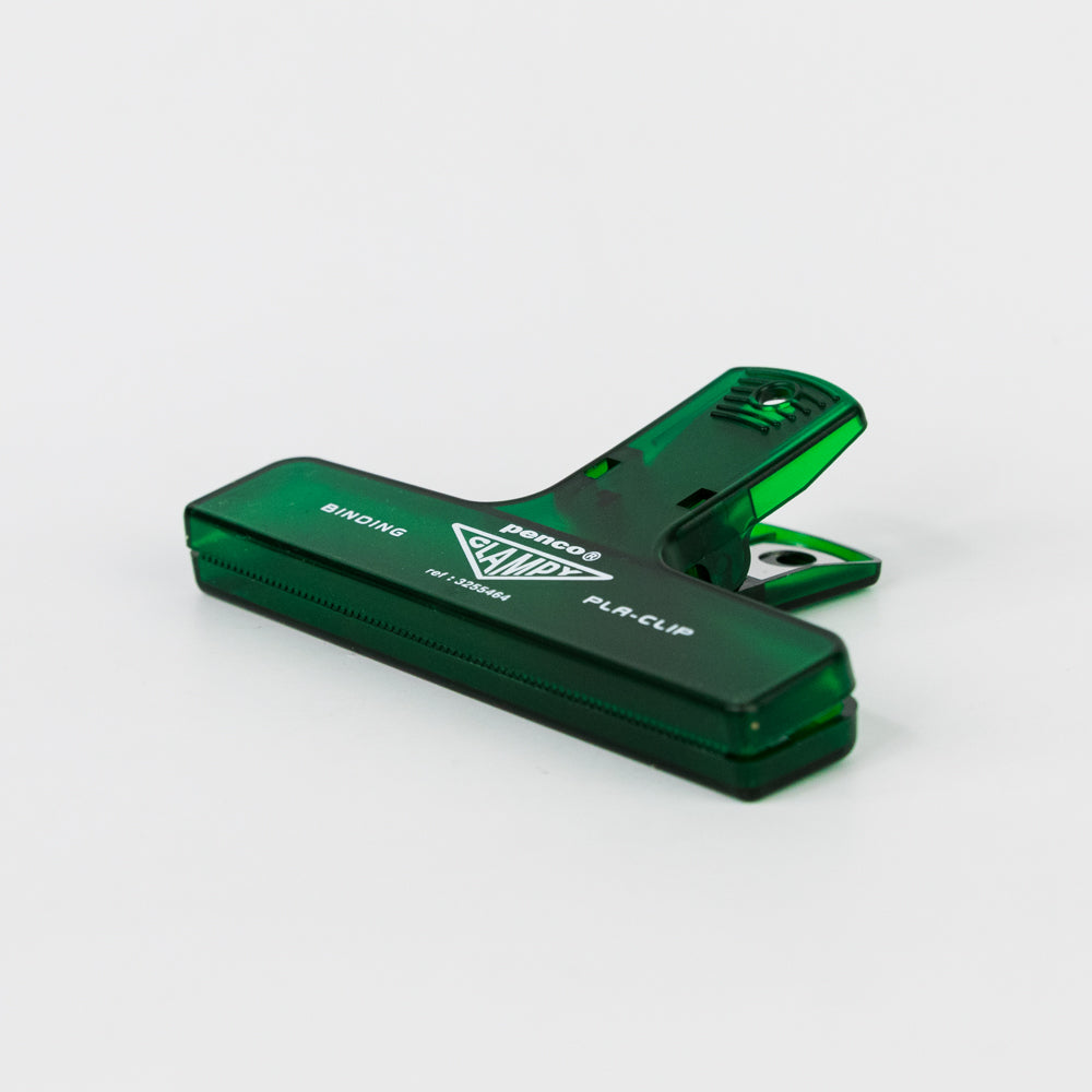 Green binding clip with 'Penco' branding on a light gray background