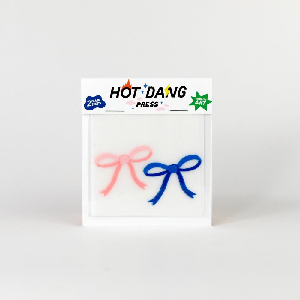Packaged iron-on decals in pink and blue bows on a white background, featuring 'Hot Dang Press' branding.