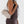 Person holding a beige handbag against a plain background