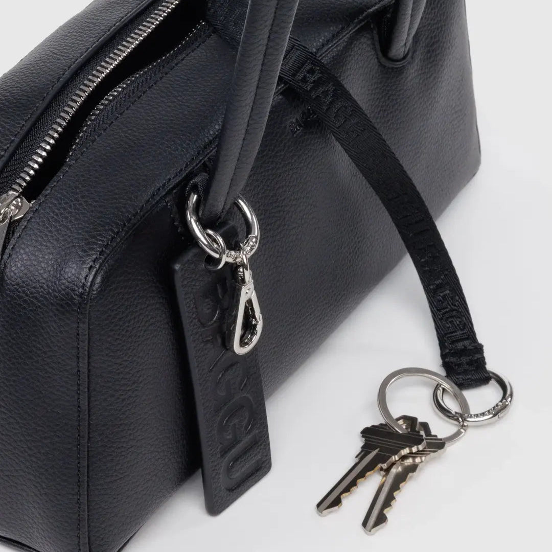 Black handbag with a keychain featuring keys on a white background